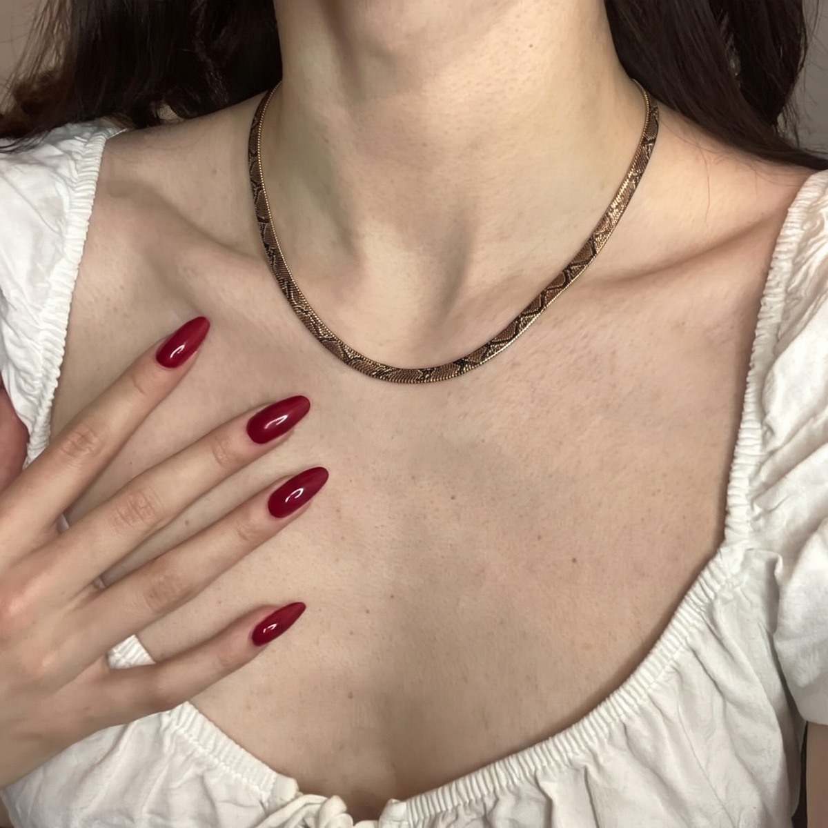 Snake print necklace worn with white neckline